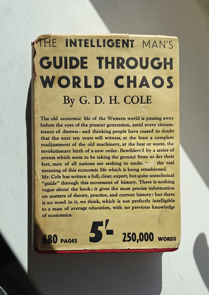 A hardback book with a typographical cover lying face up among shadows.
